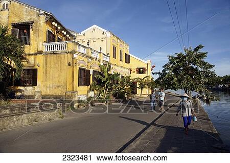 Stock Image - People Walking Along Waterfront Of Historic Town Of Hoi An; Vietnam. Fotosearch