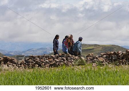 Stock Image - People walking by a field, Jatun Yampara Indigenous Community, Chuquisaca Department, Bolivia. Fotosearch