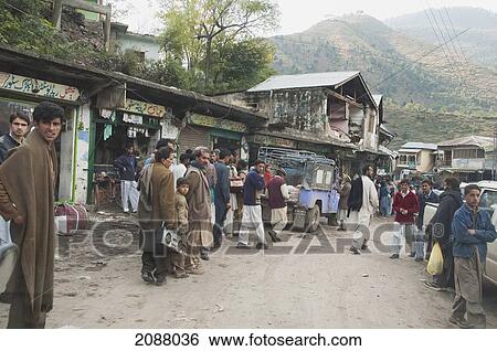 Stock Photograph - People Walking By The Bazaar Damaged By The 8 October 2005 Earthquake, Hatian, Azad Kashmir, Pakistan. Fotosearch