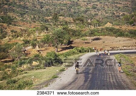 Stock Image - People walking down a road; Konso, Ethiopia. Fotosearch