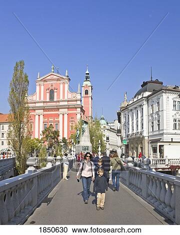 Stock Image - People Walking Over A Bridge In A City. Fotosearch