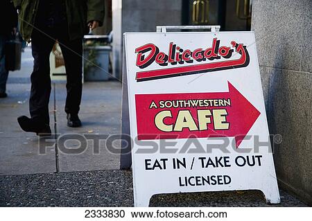 Stock Image - People Walking Past Cafe Sign On Pavement; Vancouver, British Columbia, Canada. Fotosearch