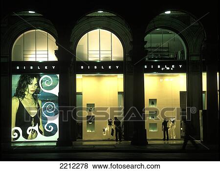 Stock Photo - People Window Shopping In The Evening In Piazza Del Duomo, Milan, Italy.. Fotosearch