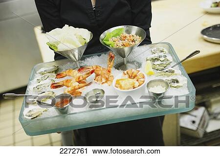 Stock Image - Person holding a platter of seafood; boston massachusetts usa. Fotosearch