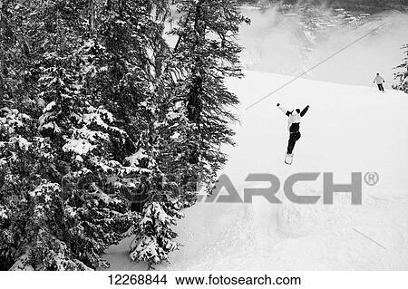 Person in air after making a jump while snowboarding, Aspen, Colorado, USA View Large Photo Image Picture - Person in air after making a jump while snowboarding, Aspen, Colorado, USA. Fotosearch