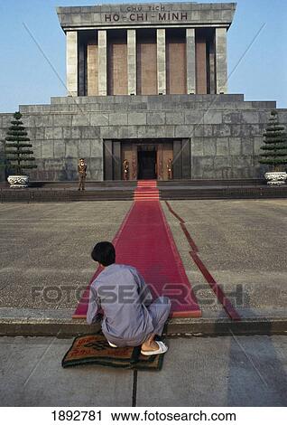 Stock Image - Person Laying Red Carpet To Ho Chi Minh Mausoleum, Rear View. Fotosearch