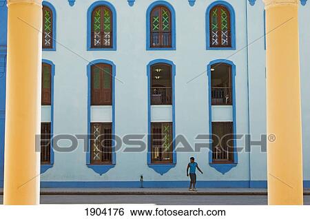 Stock Photograph - Person On Sidewalk In Front Of Ornate Building Wall, Bayamo, Granma Province, Cuba. Fotosearch