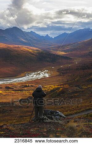 Stock Photography - Person Photographing The Colors Of Autumn Over Klondike Valley In Tombstone Territorial Park; Yukon Canada. Fotosearch