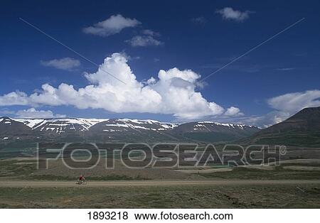 Stock Photo - Person Riding Mountain Bike On Dirt Road In Countryside. Fotosearch