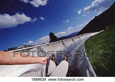 Stock Photo - Person Sliding Down A Dry Tobaggan In The Summer. Fotosearch
