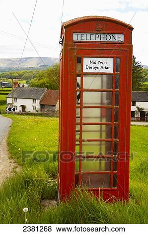 Stock Photo - Phone booth with a sign saying coins not accepted in Welsh; Brecon Beacons, Wales. Fotosearch