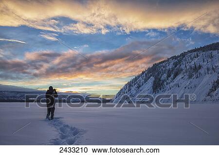 Photographer shooting the sunset over the Yukon River; Dawson City, Yukon, Canada View Large Photo Image Stock Image - Photographer shooting the sunset over the Yukon River; Dawson City, Yukon, Canada. Fotosearch