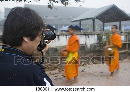 Photographer Taking Pictures Of Novice Monks Out Collecting Alms At Dawn. View Large Photo Image Stock Image - Photographer Taking Pictures Of Novice Monks Out Collecting Alms At Dawn.. Fotosearch