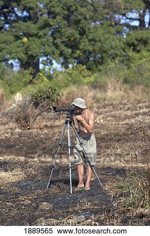 Stock Photography - Photographer Taking Pictures On Tripod. Fotosearch