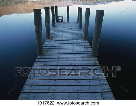 Stock Image - Pier On Calm Waters Of Derwent Water Shortly After Dawn. Fotosearch