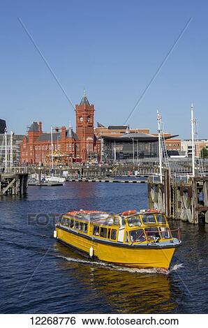 Stock Photograph - Pierhead building and boats in the harbour; Cardiff, Wales. Fotosearch