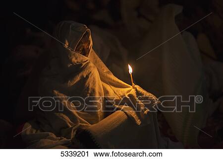 Stock Image - Pilgrim with candle; Lalibela, Ethiopia. Fotosearch