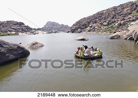 Pilgrims Float In Conical Boat Made Of Bamboo Along The Tungabhadra River In Hampi, Karnataka, India View Large Photo Image Stock Photo - Pilgrims Float In Conical Boat Made Of Bamboo Along The Tungabhadra River In Hampi, Karnataka, India. Fotosearch