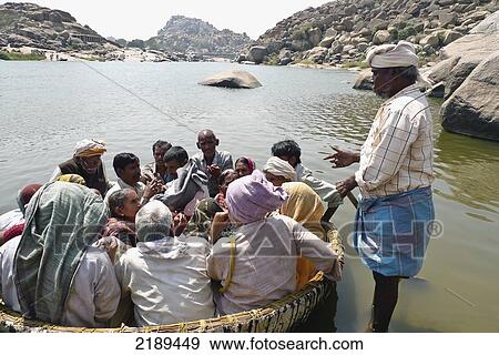 Pilgrims Float In Conical Boat Made Of Bamboo Along The Tungabhadra River In Hampi, Karnataka, India View Large Photo Image Stock Photo - Pilgrims Float In Conical Boat Made Of Bamboo Along The Tungabhadra River In Hampi, Karnataka, India. Fotosearch