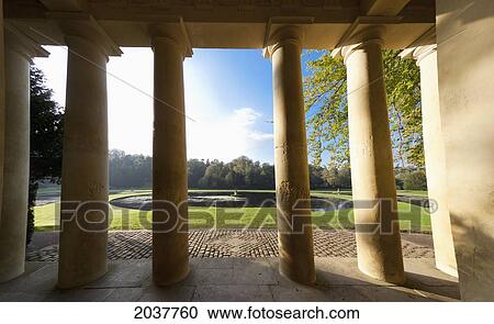 Stock Image - Pillars Of A Building Beside A Pond; Studley North Yorkshire England. Fotosearch