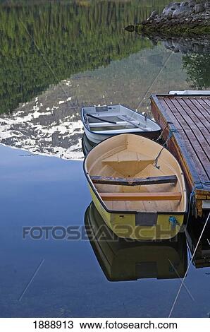 Pine Trees And Mountain Reflected In Lake Beside Row Boats View Large Photo Image Stock Image - Pine Trees And Mountain Reflected In Lake Beside Row Boats. Fotosearch