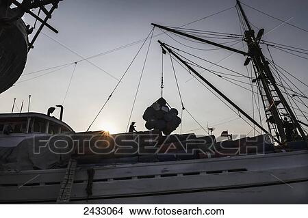 Pinisi, a traditional two masted wooden cargo sailing ship being loaded in Sunda Kelapa Harbour, Jakarta, Java Island, Indonesia View Large Photo Image Picture - Pinisi, a traditional two masted wooden cargo sailing ship being loaded in Sunda Kelapa Harbour, Jakarta, Java Island, Indonesia. Fotosearch