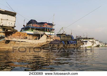 Stock Photo - Pinisi, traditional two masted wooden cargo sailing ships moored in Sunda Kelapa Harbour, Jakarta, Java Island, Indonesia. Fotosearch
