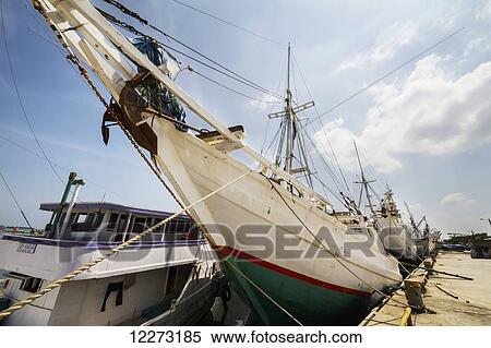 Pinisi, traditional two masted wooden cargo sailing ships moored in Paotere Harbour, Makassar (Ujung Pandang), South Sulawesi, Indonesia View Large Photo Image Stock Photography - Pinisi, traditional two masted wooden cargo sailing ships moored in Paotere Harbour, Makassar (Ujung Pandang), South Sulawesi, Indonesia. Fotosearch