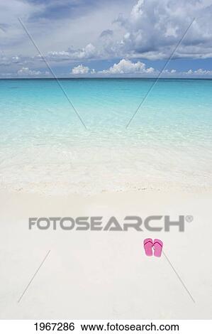 Stock Photograph - Pink Slippers On Beautiful White Sand Beach.. Fotosearch