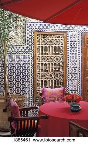 Stock Image - Pink Table With Umbrella In Moroccan Courtyard. Fotosearch