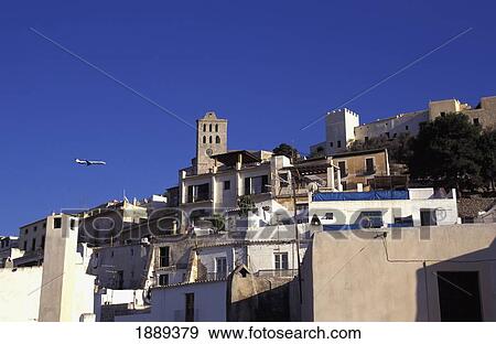 Stock Photo - Plane Flying Past Buildings. Fotosearch