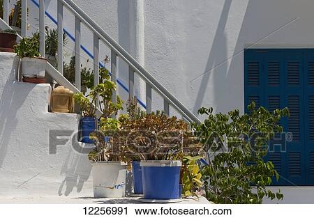 Stock Image - Plants in ceramic pots on stairs; Mykonos Town, Mykonos, Cyclades, Greek Islands, Greece. Fotosearch