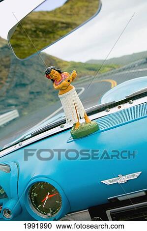 Stock Image - Plastic Hula Doll On The Dashboard Of A Turquoise Thunderbird.. Fotosearch