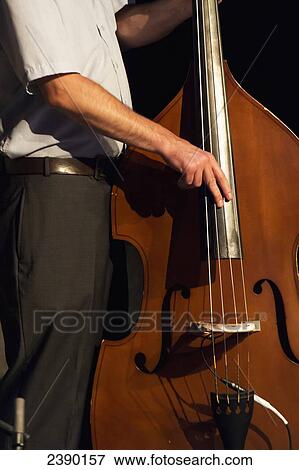 Stock Photo - Playing a double bass; Winnipeg, Manitoba, Canada. Fotosearch