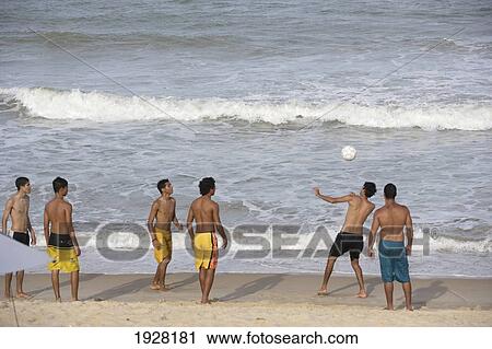 Stock Image - Playing Football On The Beach, Ponta Negra, Natal, Brazil. Fotosearch