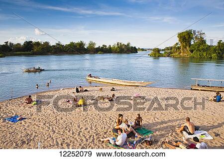 Playing on the beach on the island of Don Det on the Mekong River along the Cambodia/Laos border; Si Phan Don, Laos View Large Photo Image Stock Photo - Playing on the beach on the island of Don Det on the Mekong River along the Cambodia/Laos border; Si Phan Don, Laos. Fotosearch