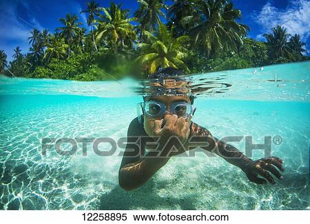 Stock Photography - Playing underwater with a young Tuvalu boy wearig goggles; Tuvalu. Fotosearch