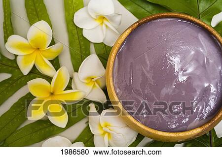 Stock Image - Poi In Wooden Bowl Surrounded By Ferns And Plumeria Flowers, View From Above.. Fotosearch