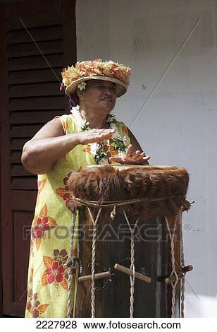 Stock Photo - Polynesia, Woman Playing Traditional Drum; Niku Hiva. Fotosearch
