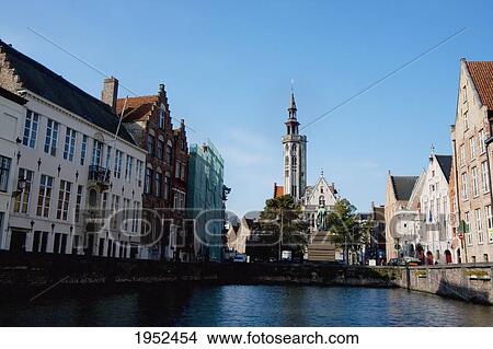 Picture - Poortersloge spire and buildings in the Hanseatic Quarter, as seen from a canal, Bruges (Brugge), West Flanders, Belgium. Fotosearch