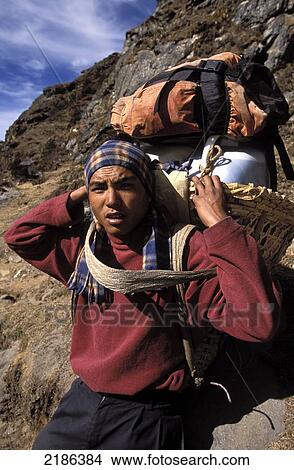 Picture - Porter / Sherpa Carrying A Heavy Load On His Back, Everest Region, Nepals. Fotosearch