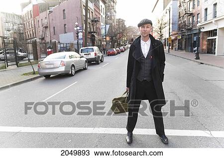 Stock Image - Portrait Of A Businessman Standing In A Street, Gastown, Vancouver, British Columbia. Fotosearch