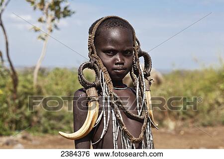 Stock Photograph - Portrait of a child decorated with tribal accessories; Omo Valley, Ethiopia. Fotosearch