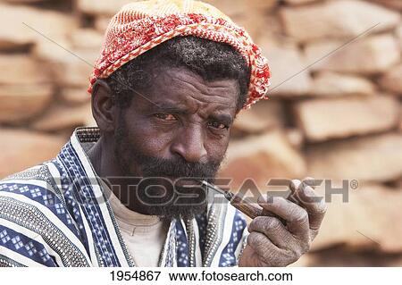 Stock Photo - Portrait of a Dogon man smoking a pipe in Tireli, Mali. Fotosearch