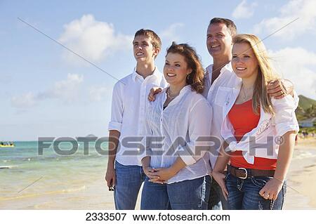 Portrait of a family wearing white shirts on the beach; Honolulu, Oahu, Hawaii, United States of America View Large Photo Image Stock Photo - Portrait of a family wearing white shirts on the beach; Honolulu, Oahu, Hawaii, United States of America. Fotosearch