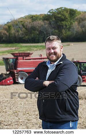 Portrait of a farmer with his farmland and equipment in the background; Minnesota, United States of America View Large Photo Image Stock Image - Portrait of a farmer with his farmland and equipment in the background; Minnesota, United States of America. Fotosearch