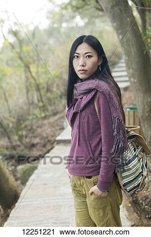 Stock Image - Portrait of a female model on a wooden boardwalk; Xiamen, China. Fotosearch