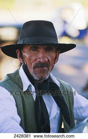 Stock Image - Portrait of a man wearing a brimmed hat and scarf; Malargue, Argentina. Fotosearch