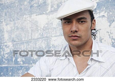 Portrait of a man with with a white hat, leaning against blue wall; Honolulu, Oahu, Hawaii, United States of America View Large Photo Image Stock Image - Portrait of a man with with a white hat, leaning against blue wall; Honolulu, Oahu, Hawaii, United States of America. Fotosearch