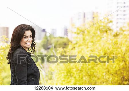 Picture - Portrait of a mature businesswoman outdoors in the river valley in autumn; Edmonton, Alberta, Canada. Fotosearch